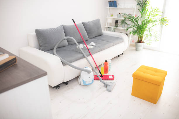 Home 10 A vacuum cleaner, mop, and various cleaning supplies arranged on a white floor, representing a professional maid service.