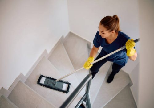 A woman mops the stairs, showcasing home cleaning services in Santa Barbara.